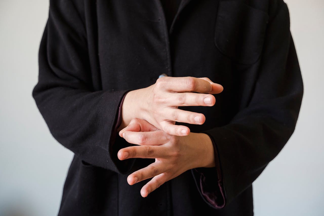 Close-up of hands gesturing in sign language on a white background.